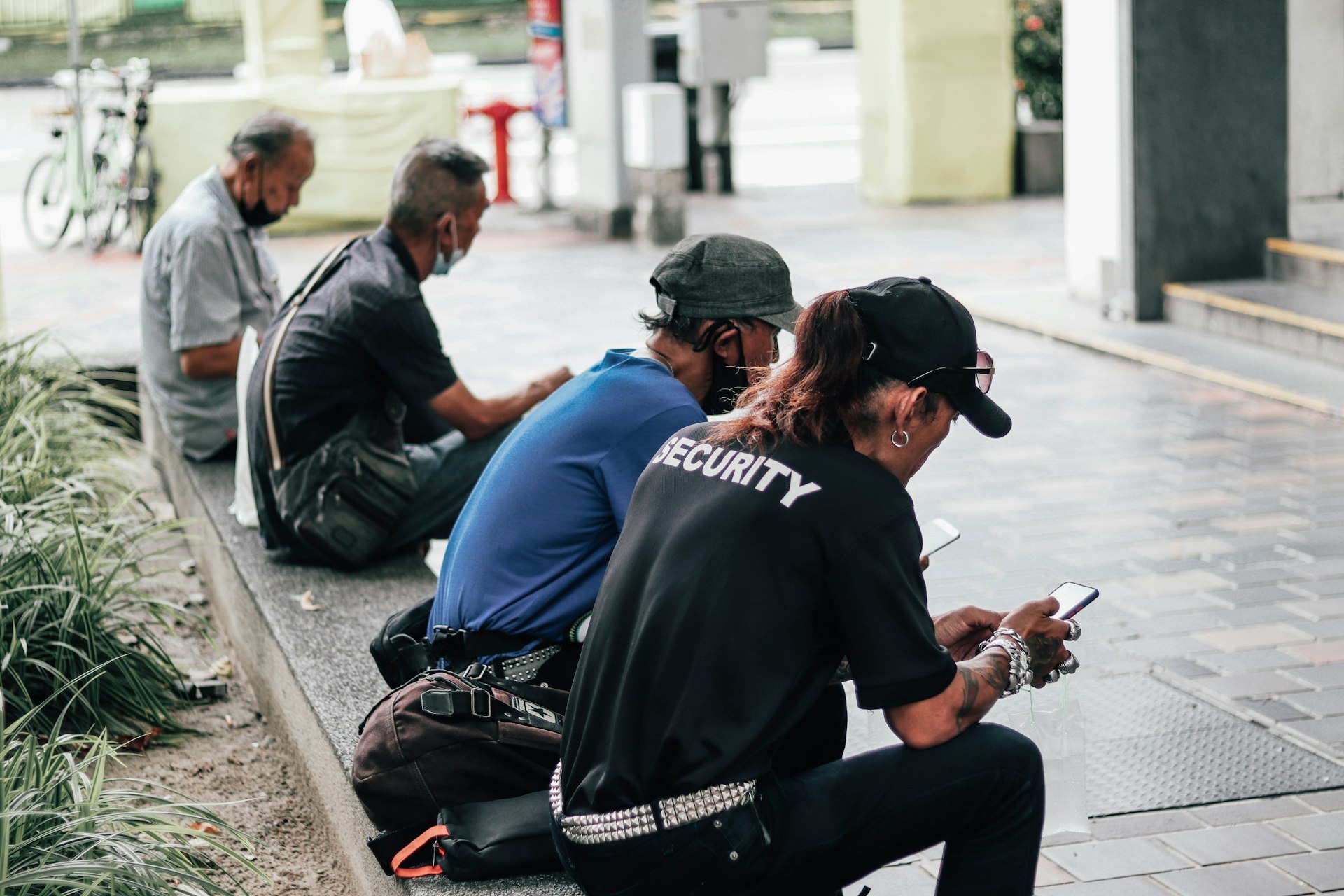 a group of people sitting on the side of a street